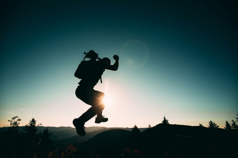 Hiker jumping symbolizing freedom from fear