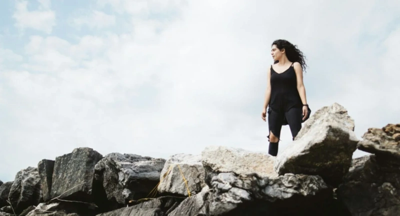 Woman on mountain top looking confident in her ability to overcome adversity