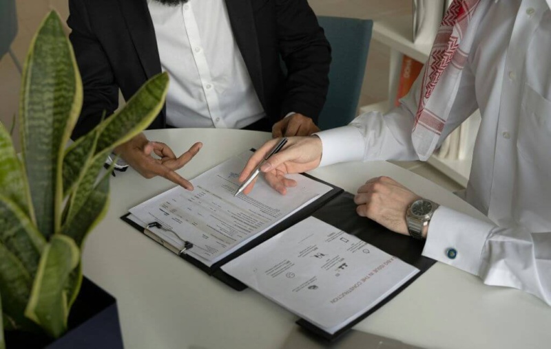 Two people signing a sales contract